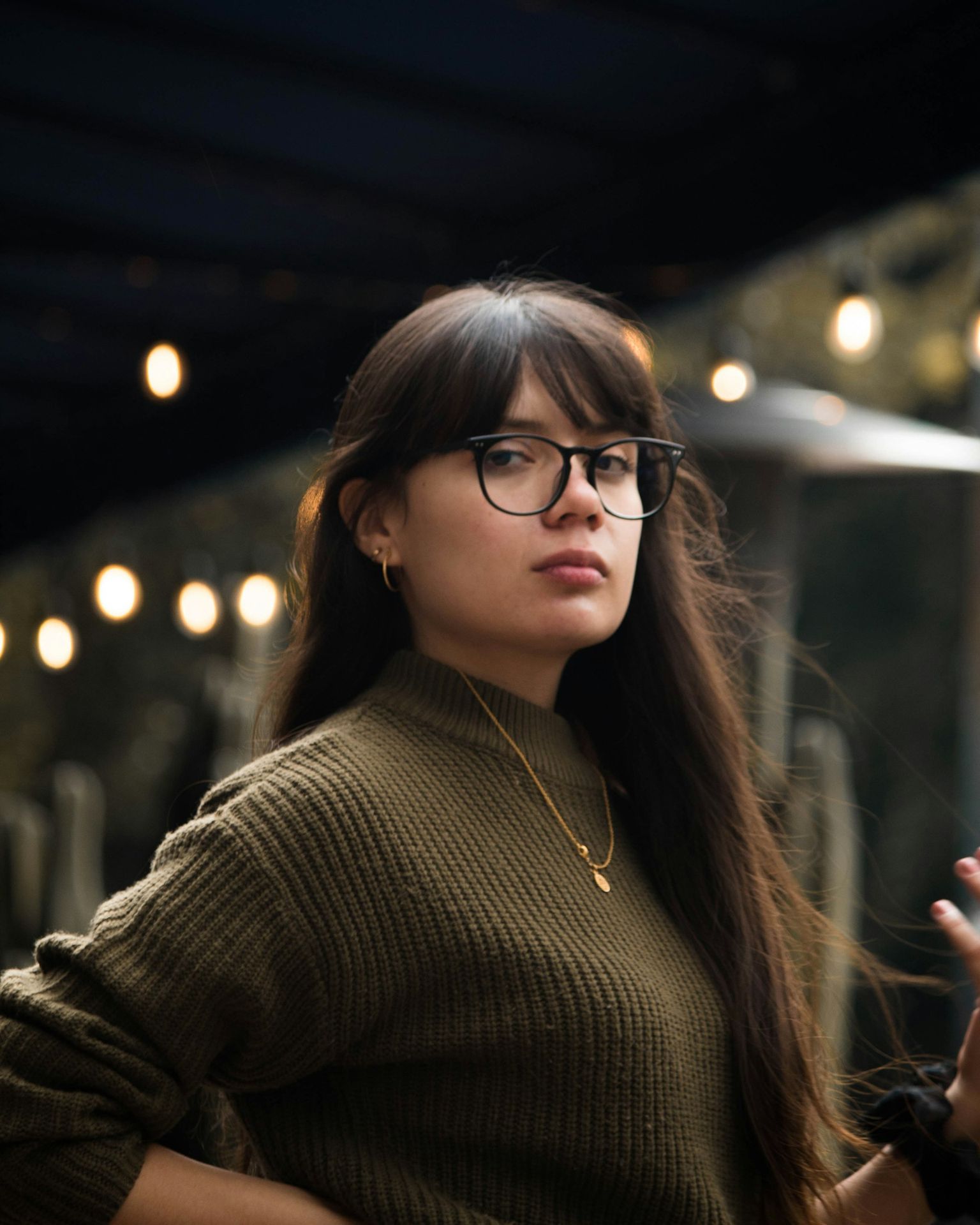 woman in black framed eyeglasses and brown sweater